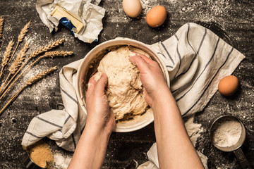 Baking - hands kneading the raw dough (pastry) in a bowl