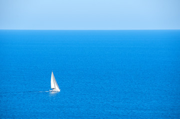 Lonely sailboat on the sea. Time of vacation and summer vacation.