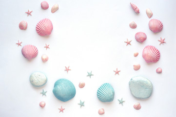 Summer time concept with painted pink and blue sea shells, starfish and stones on a white surface. Flat lay. Top view.  . Frame of shells and starfish.
