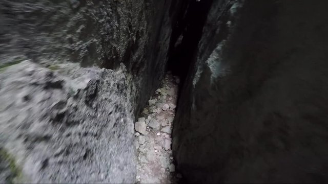 POV - a man walks through a chasm in a rock