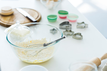 dough with whisk in bowl on kitchen counter