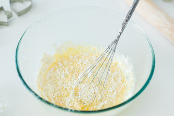 high angle view of bowl with whisk and dough in kitchen