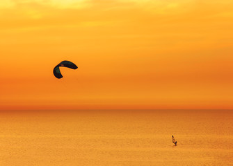 Sunset over the sea and extreme freestyle sports windsurfing in Israel.