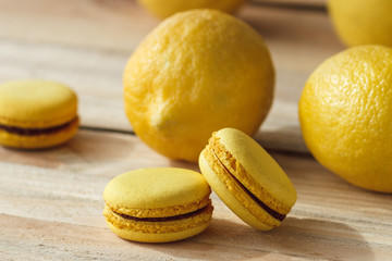 Yellow french macarons with lemons on the wooden boards