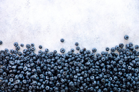 Fresh blueberries background with copy space for your text. Border design. Summer, vitamin, vegan, vegetarian concept. Healthy food. Texture of blueberry berries close up.