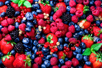 Macro colorful berries background. Top view. Summer food frame, border design. Assorted mix of strawberry, blueberry, raspberry, blackberry, currant, mint. Vitamin, vegan, vegetarian concept.