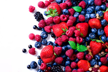 Summer berries background with copy space for your text. Top view. Food frame, border design. Mix assortment of strawberry, blueberry, currant, mint leaves. Vitamin, vegan, vegetarian concept.