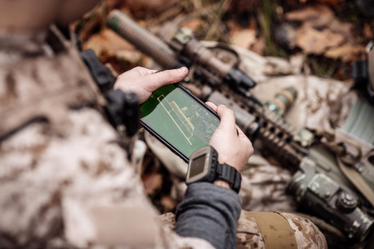 soldiers holding gps in hand and determines the location of coordinates.