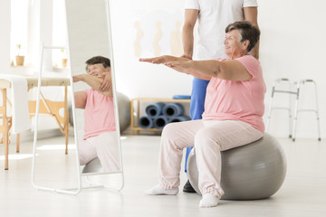 Fototapeta na wymiar Senior exercising with physiotherapist