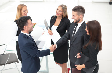 handshake of business partners after signing the contract