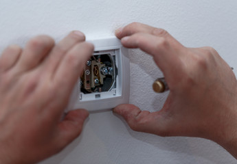 Electrician stripping the cable to connect switches and sockets of a residential electrical...