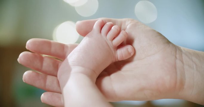 4k, newborn baby holds in the mother's hands close-up beautiful bokeh background, slow motion, maternity concept