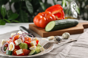fresh vegetable salad with quail eggs and cheese in pink plate on the table