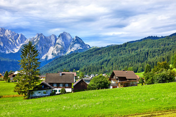 Traditional Austrian village among meadows, fields and Alpine