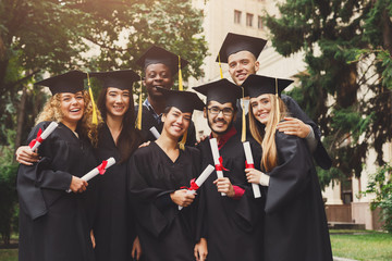Graduates having a group hug