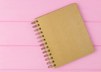 A sketchbook on a pink wooden background.
