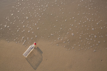 Empty plastic bottle on sea beach, environmental or polution concept