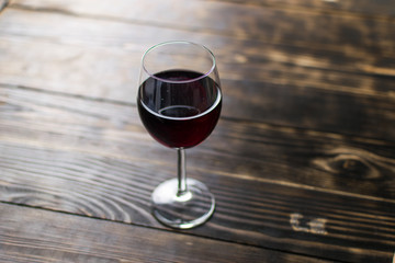 A glass of wine on a wooden background.