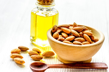 cosmetic and therapeutic almond oil on light wooden background