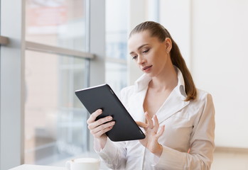 Fototapeta premium White blouse, tablet, serious