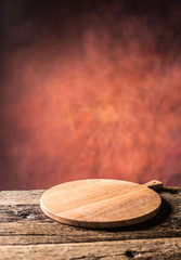 Empty pizza round board  old wooden table and colour blurred background