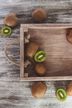 Green kiwis in the wooden tray
