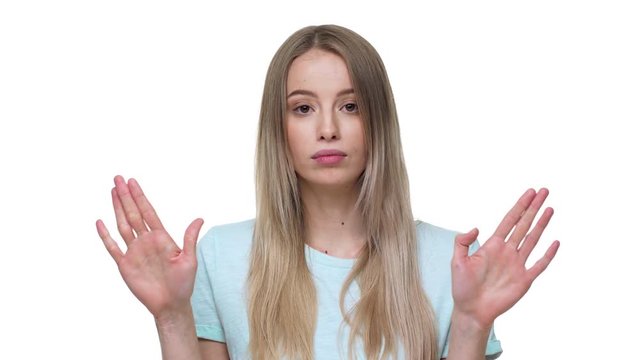 Portrait of angry blond woman expressing perplexity and confusion with showing stop gestures and saying no, isolated over white background closeup. Concept of emotions