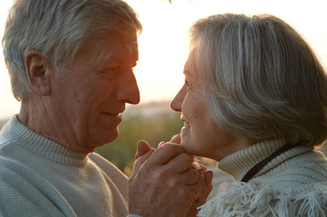 Happy elderly couple at beautiful sunset 