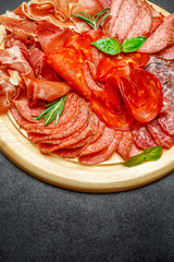 Cold meat plate with salami and chorizo sausage on wooden board