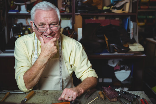 Portrait of shoemaker with hand on chin