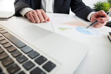 Close up view of bookkeeper or financial inspector hands making report, calculating or checking balance. Marketing strategy brainstorming. Paperwork and digital in office.