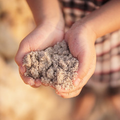 kid playing sand at the beach