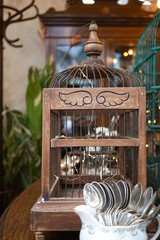 Vintage wooden bird cage with selective focus on the wings carved on wood