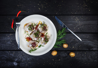 Russian snack from salted herring, potatoes and cucumbers