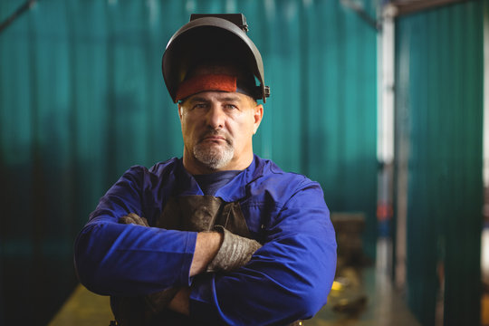 Portrait of male welder standing with arms crossed