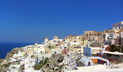 Fototapeta na wymiar Oia town on Santorini island, Greece. Traditional and famous houses and churches with blue domes over the Caldera, Aegean sea