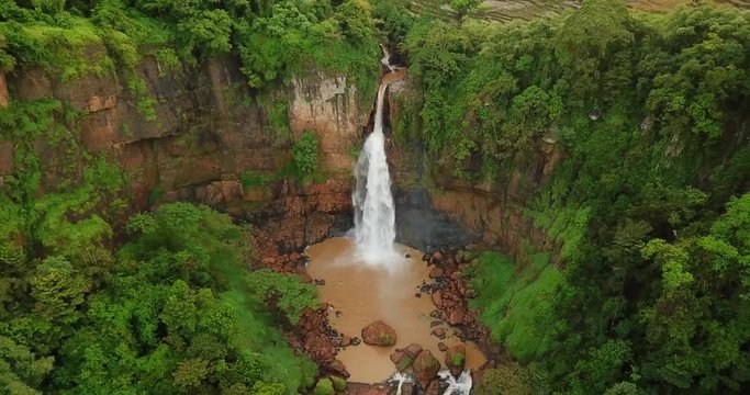 Beautiful aerial shot of Cimarinjung waterfall from a drone flying backward at Ciletuh Geopark, Sukabumi, West Java, Indonesia. Shot in 4k resolution