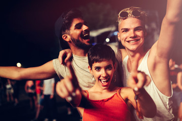 Happy friends having fun at music festival