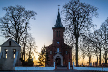 Zabytkowy kościół na wzgórzu oświetlony zachodzący słońcem w miejscowości Górka Pabianicka, Polska © Senatorek