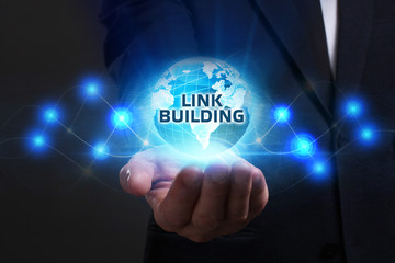 Business, Technology, Internet and network concept. Young businessman working on a virtual screen of the future and sees the inscription: Link building