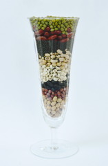 Fototapeta na wymiar raw variety bean and cereal plant in glass on white background