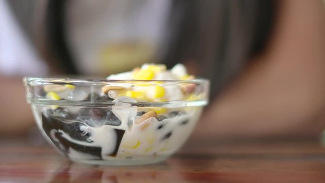 Eating thai traditional coconut ice cream dessert with grass jelly