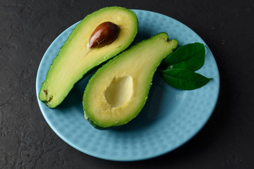 Fresh avocado fruit on a black rustic board. The concept of healthy eating. Food photography