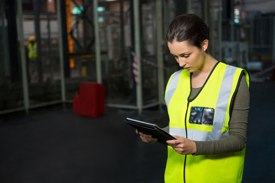 Female worker using digital tablet in warehouse