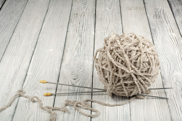 Ball of wool with spokes for handmade knitting on wooden table. Knitting wool and knitting needles.