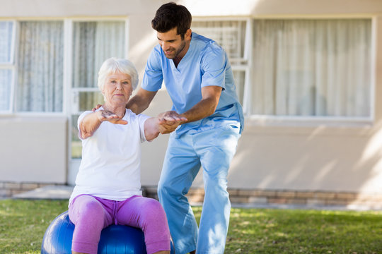 Nurse helping senior woman doing exercices