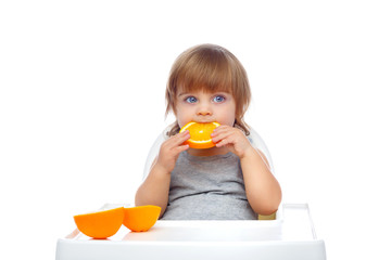 a handsome baby 1.6 years old sits in a white child's highchair. The concept of baby food. Food.