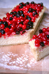 Pie cheesecake with berries on wooden plate 