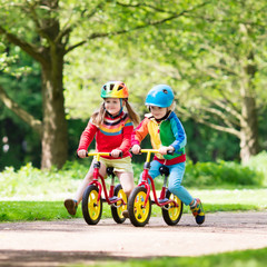 Fototapeta premium Kids ride balance bike in park
