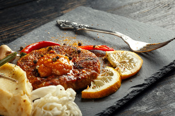 Beef steak with mashed potatoes, spices and sauce.